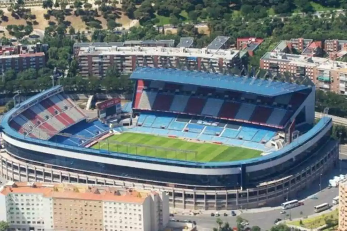 Aerial view of a football stadium surrounded by buildings and green areas.